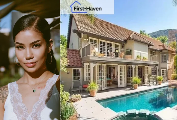 Jhené Aiko House with a pool surrounded by lush greenery, showcasing a Mediterranean-style design with large windows and a tiled roof.